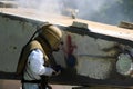 Worker is remove paint by air pressure sand blasting