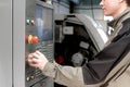 Worker removes the part from CNC lathe machine. Turning machine for drilling with the drill tool and center drill tool .The hi- Royalty Free Stock Photo