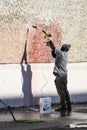 Worker removing graffiti from a wall in Seattle