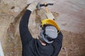 Worker removing plaster from the wall with tools Royalty Free Stock Photo