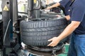 Worker removing tire from the rim using machinery at workshop Royalty Free Stock Photo