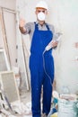 Worker repairer standing with electric saw in mask