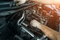 Worker repairing car and changes spark plugs in car engine in auto service, close up Royalty Free Stock Photo