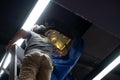 Worker repairing a ceiling air conditioning unit