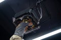 Worker repairing a ceiling air conditioning unit