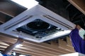 Worker repairing a ceiling air conditioning unit