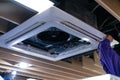 Worker repairing a ceiling air conditioning unit