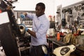 Worker repairing failed scooter in motorcycle garage Royalty Free Stock Photo