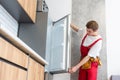 Worker repairing fridge in kitchen Royalty Free Stock Photo