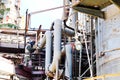 Worker repairman fitter welder repairs a pipeline at a refinery petrochemical chemical industrial plant. A welder in a cradle is