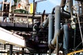 Worker repairman fitter welder repairs a pipeline at a refinery petrochemical chemical industrial plant. A welder in a cradle is