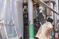 Worker repairman fitter welders in a mask repairing a pipeline, brewing a pipe, repairing equipment at an oil refining Royalty Free Stock Photo