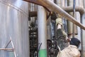 Worker repairman fitter welders in a mask repairing a pipeline, brewing a pipe, repairing equipment at an oil refining Royalty Free Stock Photo