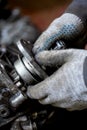 A worker repairs a car`s transmission