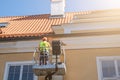 Worker repairs the facade of the building. Security cart