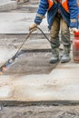 A worker repairs a road by heating a damaged asphalt pavement with a gas burner Royalty Free Stock Photo