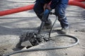 A worker repairs the road with a jackhammer. Royalty Free Stock Photo