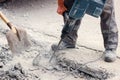 A worker repairs the road surface with a jackhammer on a summer day. Construction works on the road. Royalty Free Stock Photo