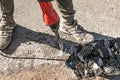 A worker repairs the road surface with a jackhammer on a summer day Royalty Free Stock Photo