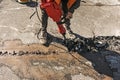 A worker repairs the road surface with a jackhammer on a summer day Royalty Free Stock Photo