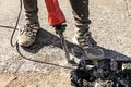 A worker repairs the road surface with a jackhammer on a summer day Royalty Free Stock Photo