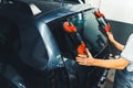 Worker replacing windscreen of car in a service station windshield replacement