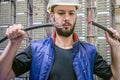 Worker restores the connection in the data center server room. Engineer in a helmet will connect damaged Internet backbone wire. Royalty Free Stock Photo