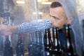 Worker righting bottle on production line