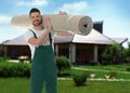 Worker with rolled carpet outdoors on sunny day Royalty Free Stock Photo