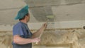 Worker with roller covers the ceiling with primer