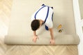 Worker rolling out new carpet flooring indoors, top view Royalty Free Stock Photo