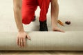 Worker rolling out new carpet flooring indoors, closeup Royalty Free Stock Photo