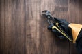 worker\'s gloved hand holds a pliers tool on a wooden background Royalty Free Stock Photo