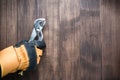 worker\'s gloved hand holds a pliers tool on a wooden background Royalty Free Stock Photo