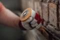 Builder`s strong hands working with hammer and chisel at the construction site