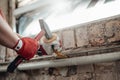 Builder`s strong hands working with hammer and chisel at the construction site