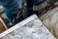 Worker`s hand measuring tile to be cut. Royalty Free Stock Photo