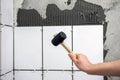 The worker hand is putting tiles adhesive to the wall with the notched trowel Royalty Free Stock Photo