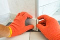 Worker`s hands Instal plastic skirting board and decorative caps. Renovation of baseboard at home. Royalty Free Stock Photo