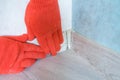 Worker`s hands Instal plastic skirting board and decorative caps. Renovation of baseboard at home Royalty Free Stock Photo