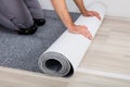 Worker`s Hands Unrolling Carpet On Floor Royalty Free Stock Photo