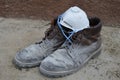 Worker`s shoes dirty from all-day work construction dust on leather boots on concrete with mask protecting lungs from dust Royalty Free Stock Photo