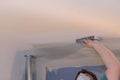Worker sanding the drywall ceiling mud using sand trowel during renovation the house Royalty Free Stock Photo