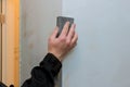 Worker sanding the drywall mud using sand trowel during renovation the house Royalty Free Stock Photo