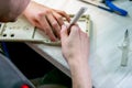 A worker sanding a plastic blank. Manufacturing of plastic products. Medium business concept. Hands close-up