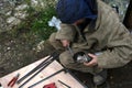 Worker sawing metal with electrical saw, grinder.