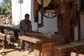 Sur, Oman - November 27 2019 Worker sawing ship planks in traditional dhow wharf in Sur, Oman