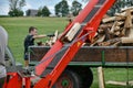 A worker at a sawmill operates a hydraulic plant for chopping and sawing logs for firewood