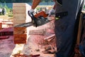 A worker saws off a chainsaw wood Board. House construction