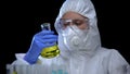 Worker of scientific lab analyzing flammable liquid in flask, toxic igniter